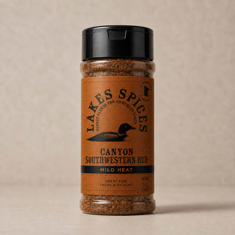 A 5oz bottle of Lake Spices Canyon Southwestern Rub, featuring the company logo of a black loon on an orange-brown background, and a black icon of Minnesota in the upper righthand corner. Label text above the loon reads “Lake Spices: Honest Blends for Homemade Taste.”